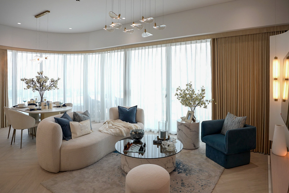 Beach Walk Residence A modern, stylish living room with large windows, cozy furniture, a dining area, and elegant decor accents.